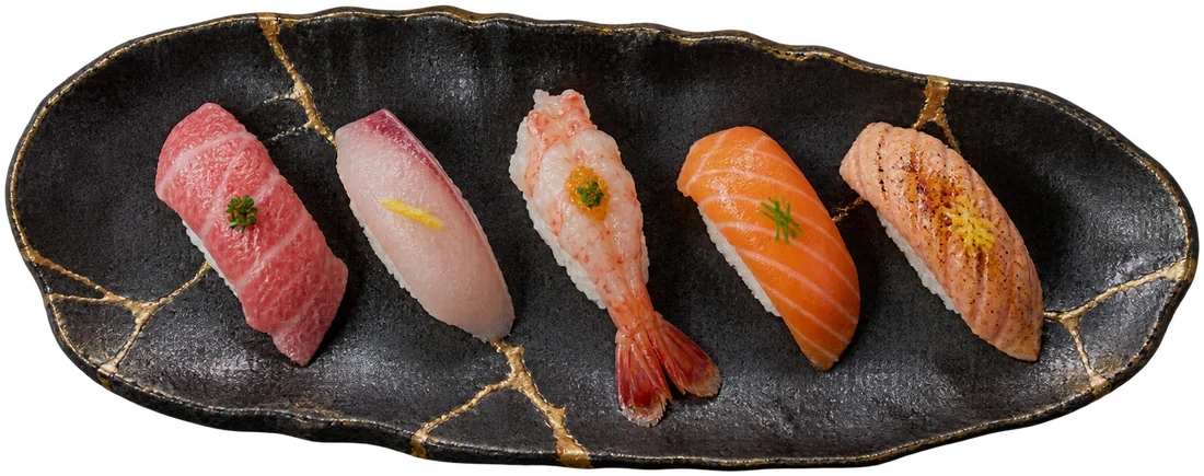 Five-piece nigiri selection — tuna, yellowtail, prawn, salmon and seared salmon — on a kintsugi plate at Yuzu Sushi and Bar, Reno Nevada